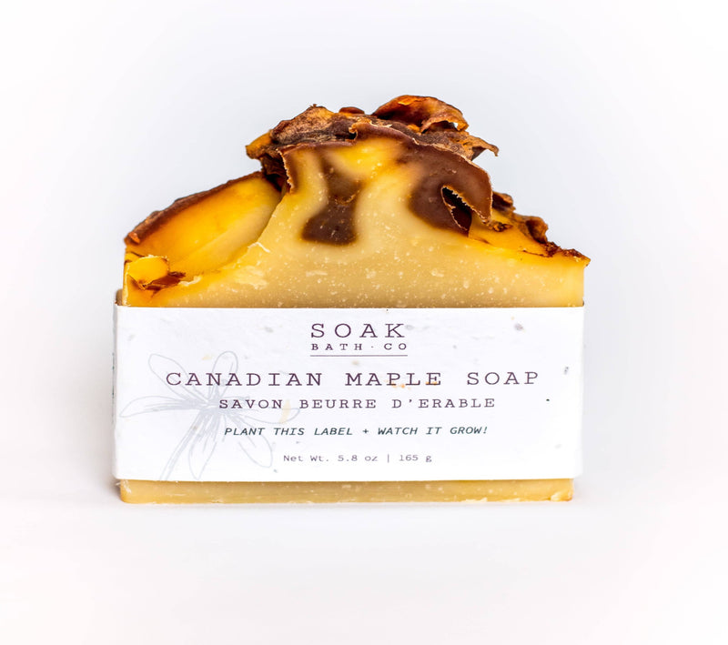 A soap bar of SOAK Bath Co. - Canadian Maple Soap Bar, featuring a creamy base with a top layer adorned with intricate maple leaf designs, set against a white background.