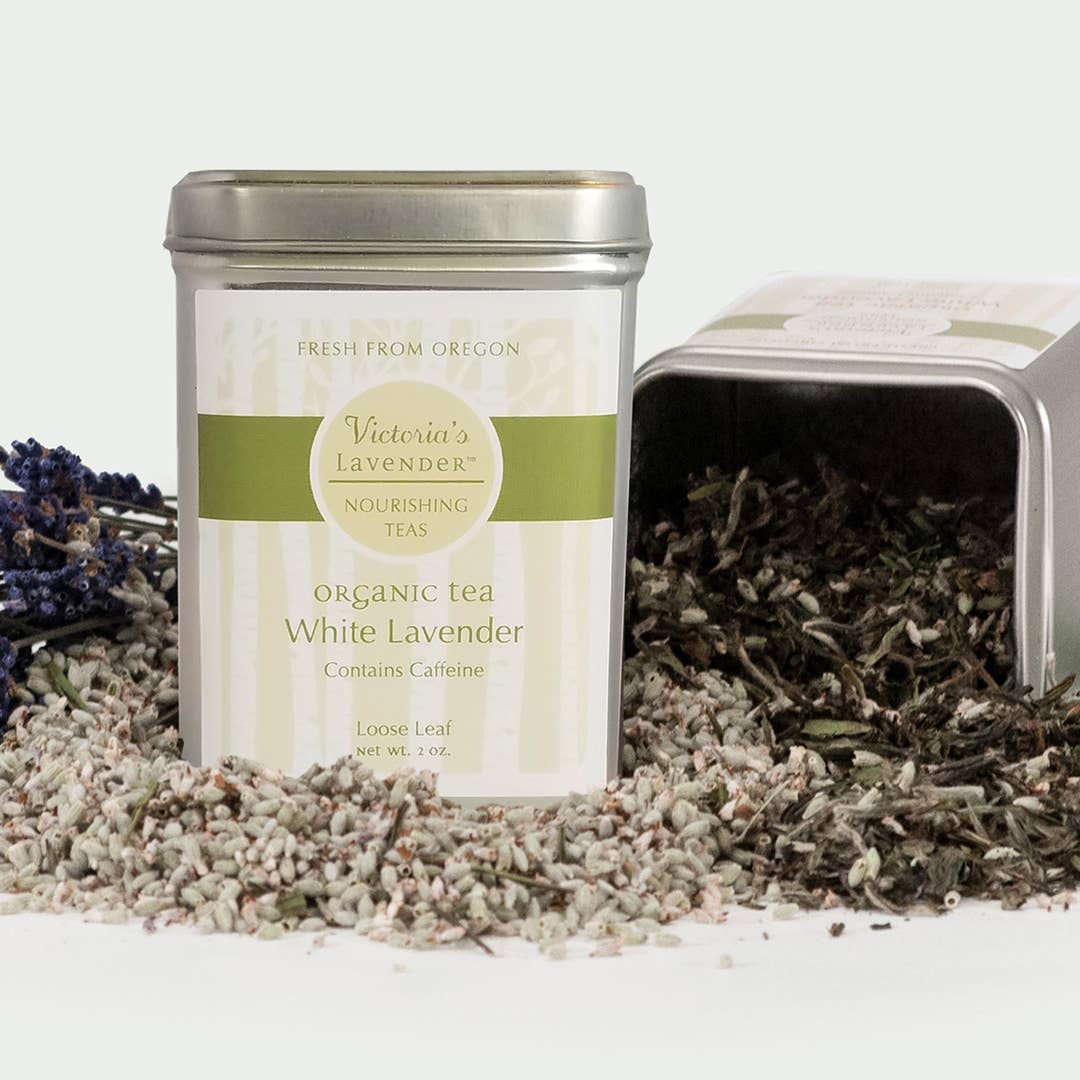 Two tins of Victoria's Lavender Organic Tea - White Lavender, Loose Leaf, one open showing loose white lavender tea leaves, against a white background.