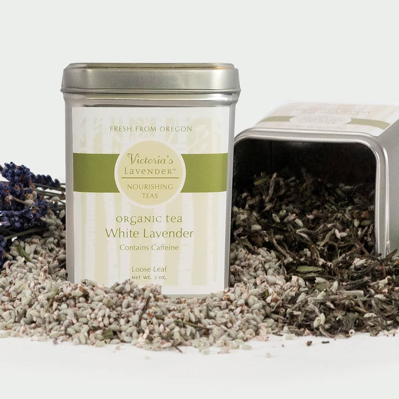 Two tins of Victoria's Lavender Organic Tea - White Lavender, Loose Leaf, one open showing loose white lavender tea leaves, against a white background.