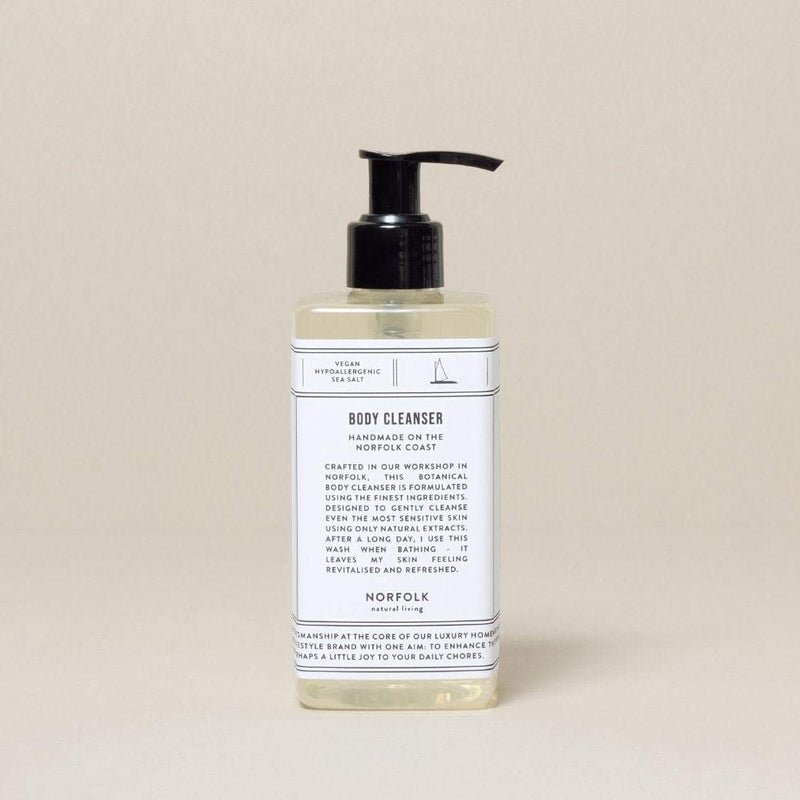 A bottle of Norfolk Natural Living Coastal Body Cleanser - 300ml with a pump dispenser, labeled in a simple, modern font. The label provides information about the product including its herbal and coastal ingredients enriched with coconut oil.