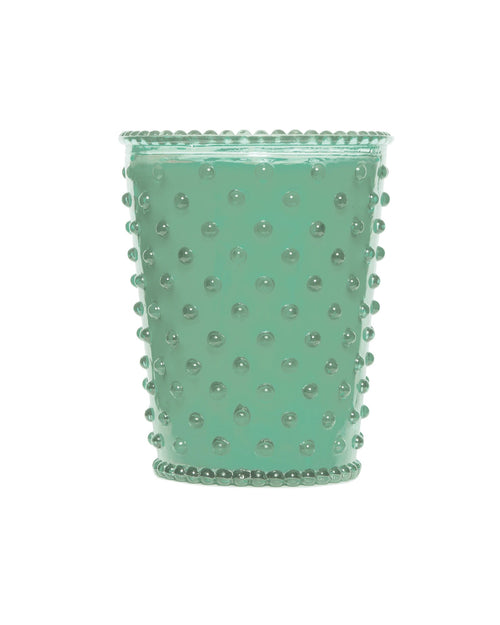 A light green, textured glass cup with raised dot design, Simpatico NO. 95 Eucalpytus Hobnail Glass Candle isolated on a white background.