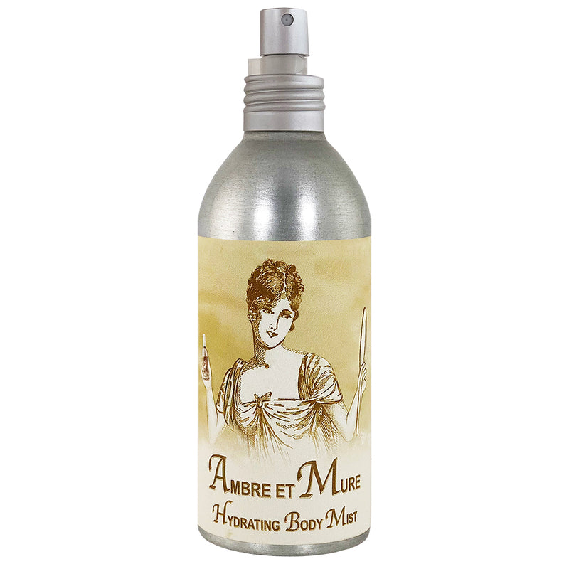 A silver and beige bottle of "La Bouquetiere Ambre et Mure Hydrating Body Mist," featuring a vintage illustration of a woman holding a wand on the label.
