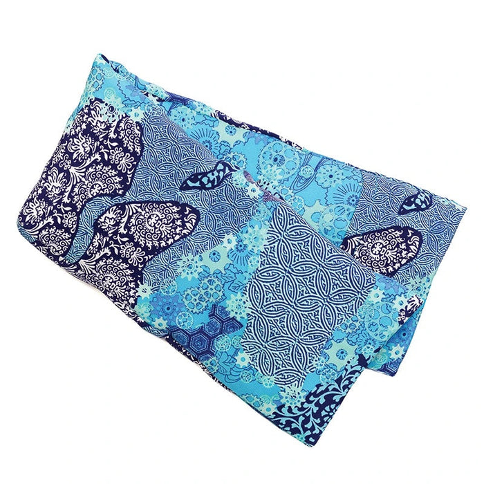 The elizabeth W Silk Hot/Cold Flaxseed Pack in Aqua Origami showcases a folded fabric with floral and geometric blue patterns. The shades range from dark to light, making it vibrant and intricate, perfect for versatile use.