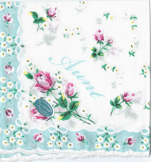 An intricately designed colorful floral hanky with pink roses and small white flowers, featuring the word "aunt" written elegantly in script, highlighted by a lace border and a seal reading Hankies ala Carte.