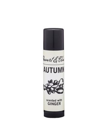 A cylindrical, black and white bottle of Stewart & Claire - Autumn hand cream labeled "autumn" and scented with ginger and organic jojoba, decorated with a simple vine design.
