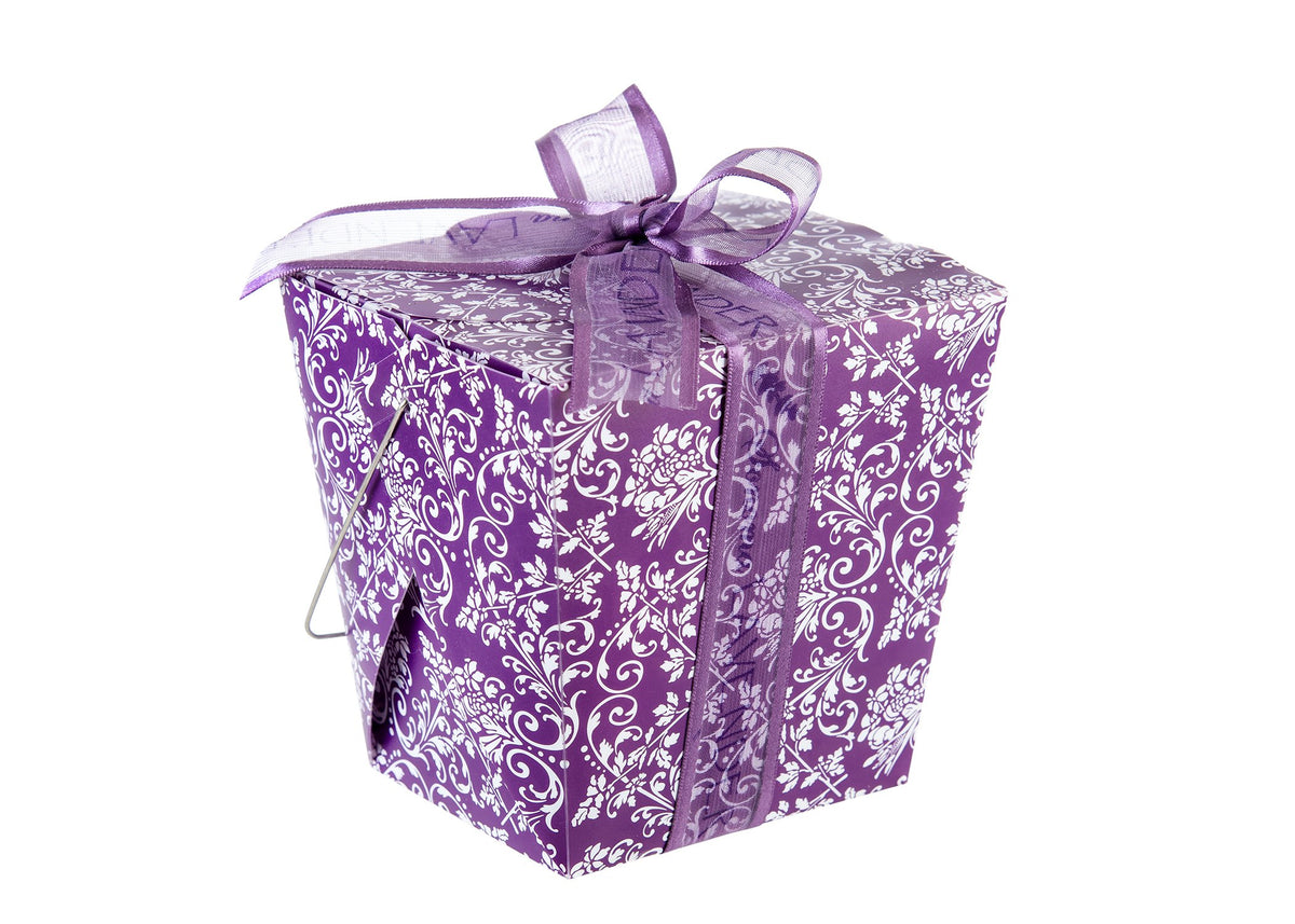 A Sonoma Lavender Take-Out-Box with ornate white patterns and a translucent lavender ribbon tied in a bow, isolated on a white background.