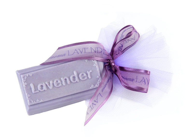 A bar of Sonoma Lavender Guest Soap - Lavender Bar wrapped in white tulle with a purple ribbon, isolated on a white background.