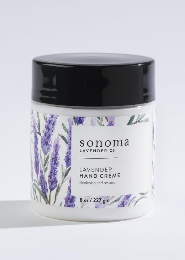 A container of Sonoma Lavender Hand Creme labeled "antioxidant-rich lavender hand creme, replenish and restore," featuring lavender illustrations, on a white background.