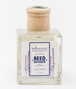 A square glass BC Essentials - Lavender Reed Diffuser - 6oz bottle with a wooden cap and a label showing the brand "bc essentials aromatherapy co." with lavender scent description, against a white background.