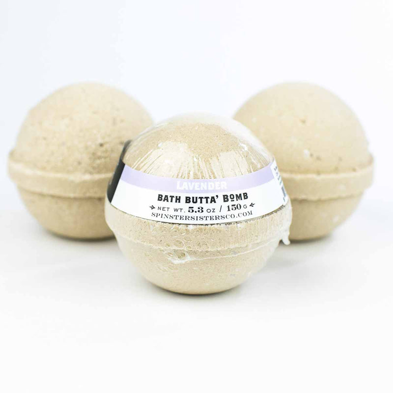 Three Spinster Sisters Bath Butta' Bomb - Lavender with fair-trade shea butter, displayed against a white background. The bath bombs are spherical and textured.