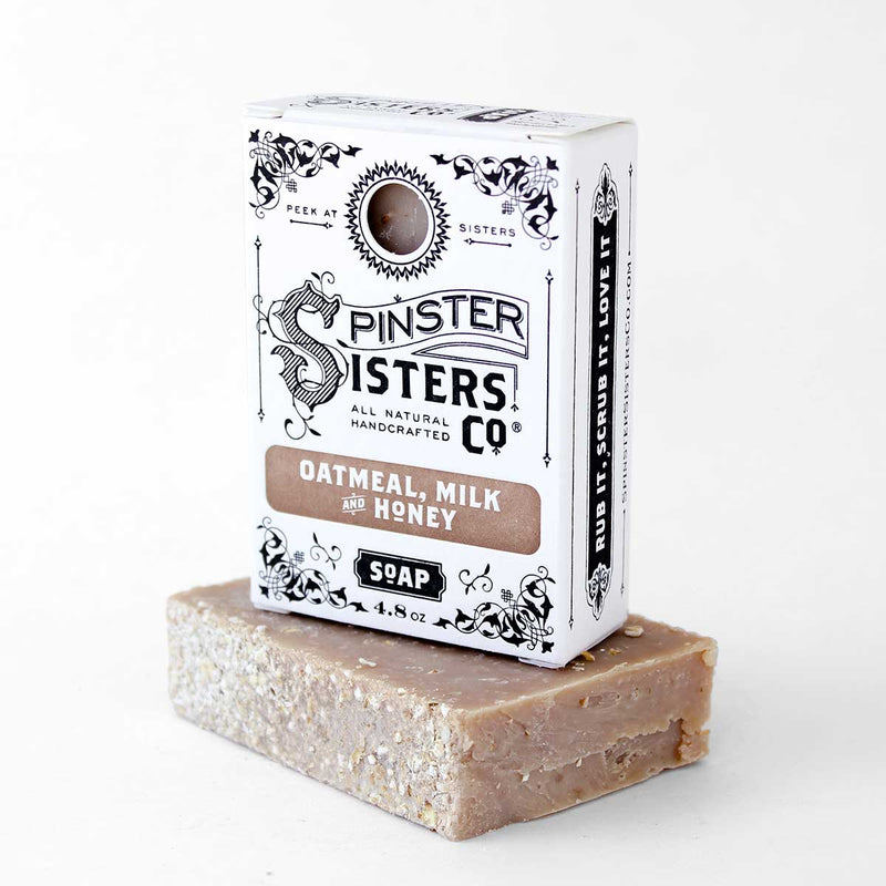 A bar of Spinster Sisters Bath Soap - Oatmeal Milk and Honey beside its biodegradable packaging featuring intricate black and white designs and text.