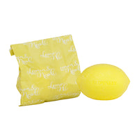 A lemon-shaped and colored luxurious soap set from Bronnley English Soaps, next to a yellow patterned fabric pouch with "merveille" script text on it, isolated on a white background.