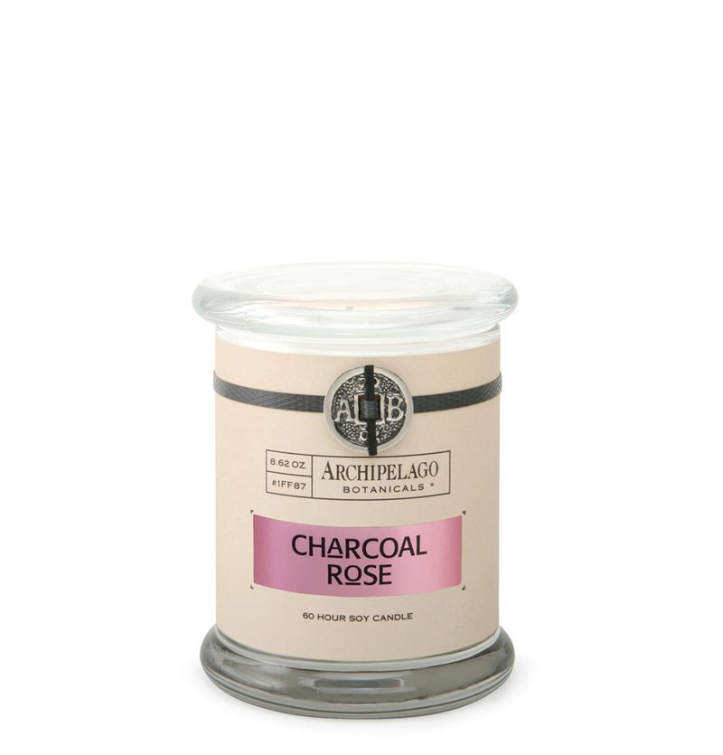 A glass jar candle labeled "Archipelago Charcoal Rose Jar Candle" with a cream band, purple label, and a 60-hour soy wax indication, on a white background.