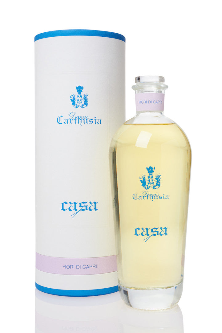 A bottle of Carthusia I Profumi de Capri Reed Diffuser & Refill 500ml next to its cylindrical packaging on a white background. Both items feature light blue and white colors with the brand's logo.