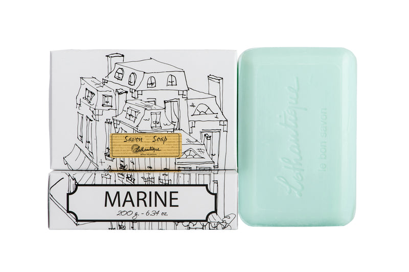 A bar of Lothantique Marine Vegetable Soap beside its packaging, which features a black and white sketch of coastal buildings. The packaging reads "savon soap" and "marine.