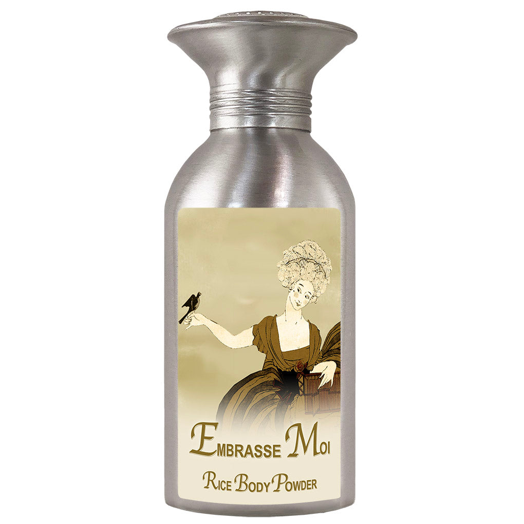 Silver-colored bottle of "La Bouquetiere Embrasse Moi Body Powder" with a vintage label featuring an illustration of an 18th-century woman holding a bird.