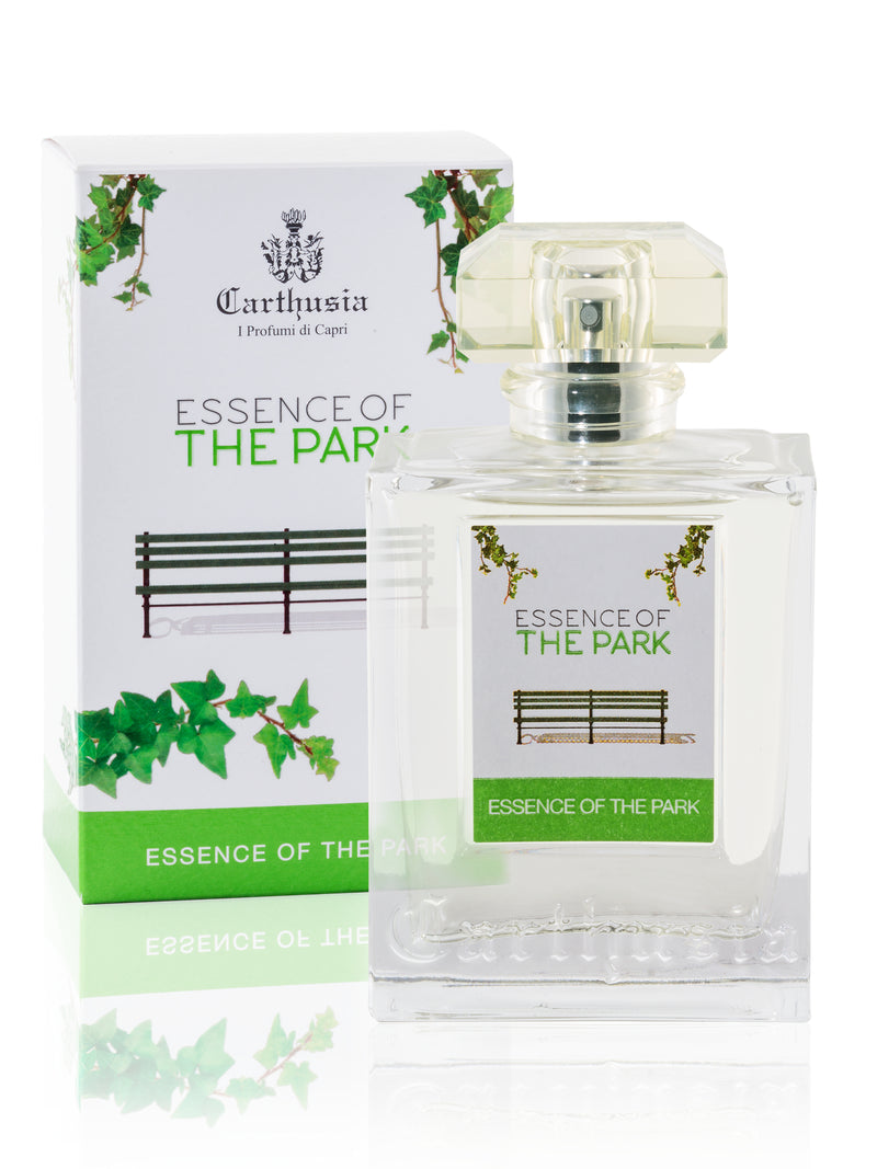 A transparent perfume bottle labeled "Carthusia Essence of the Park" alongside its box adorned with green vines and a park bench design, reflecting a clean and sophisticated style.