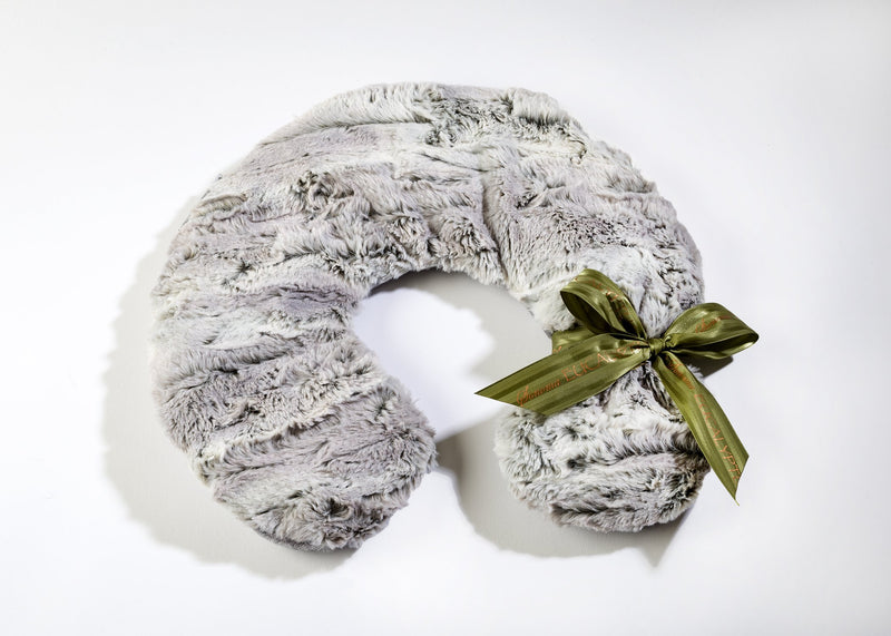 A plush, grey Sonoma Eucalyptus Silver Fox Neck Pillow adorned with a shiny green bow, positioned against a white background.