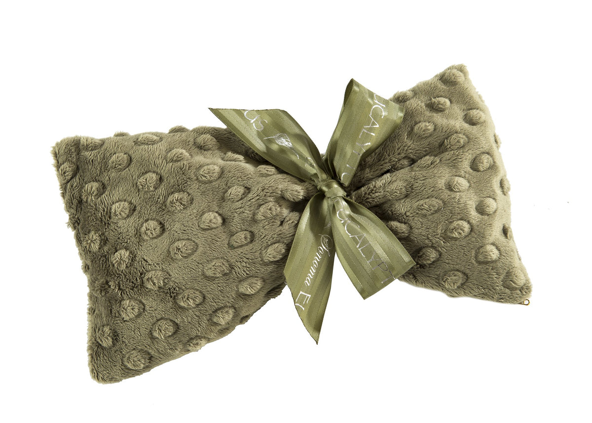 A plush, Sonoma Lavender Sonoma Eucalyptus Spa Green Dot Sinus Mask adorned with a satin ribbon in the center, featuring a textured pattern of raised dots and branded detailing on the ribbon. Includes flaxseed-filled inserts for added comfort.