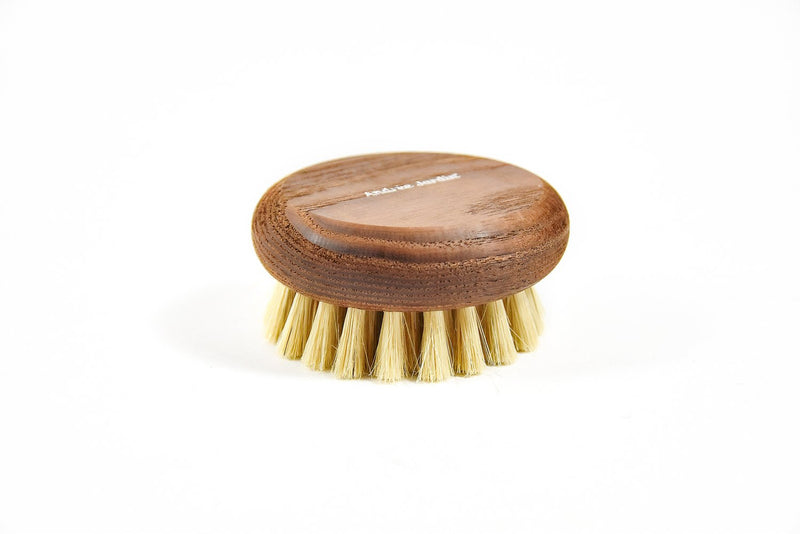 A small, round, thermo-heated Andrée Jardin Heritage Scrub Brush with natural bristles, isolated on a white background. The wood is engraved with the text "facial dry brush.