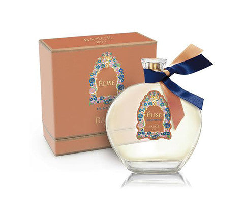 The Rancé Élise eau de parfum 50ml bottle features a floral design with a blue ribbon and is accompanied by an orange box. Both emit Sicilian Mandarin notes, while patchouli and musk scents enchant the surroundings.