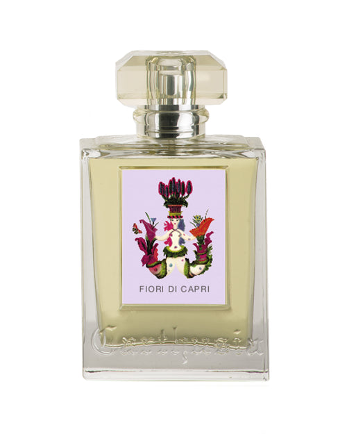 Square perfume bottle with a clear glass design, containing light yellow Carthusia Fiori di Capri Eau de Parfum - 100ml, and labeled "fiori di capri" with a colorful floral image. Brand Name: Carthusia I Profumi de Capri.