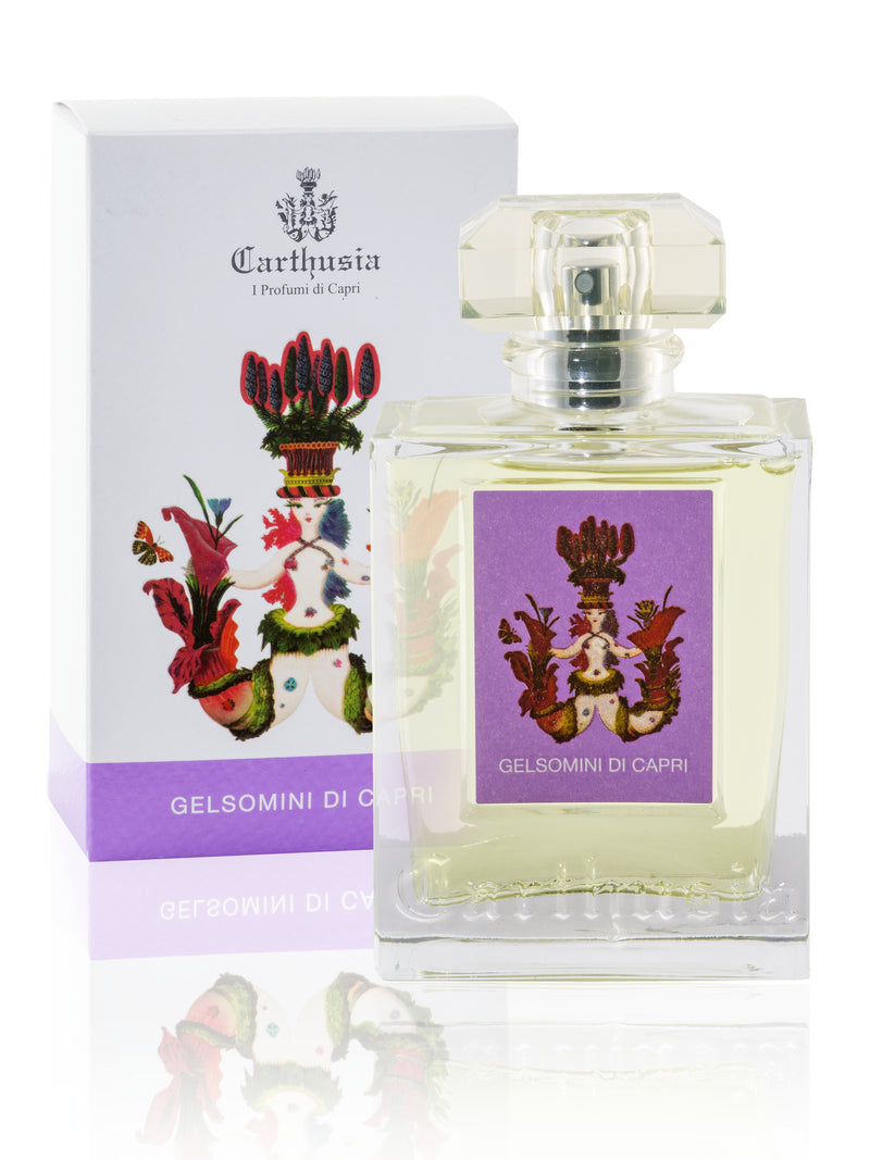 A bottle of "Carthusia Gelsomini di Capri" perfume by Carthusia I Profumi de Capri next to its packaging. The clear glass bottle has a square shape and a decorative top, featuring jasmine, set against