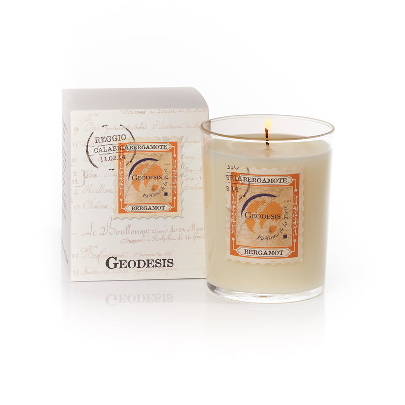 A Geodesis Bergamot 220gm scented candle in a clear glass jar beside its packaging, which features elegant script and vintage-style labels.
