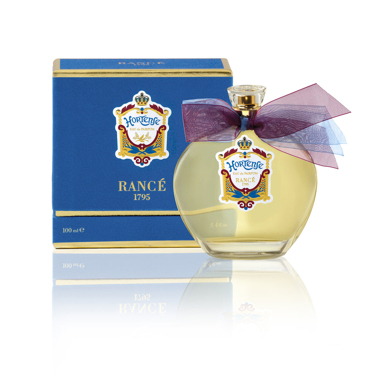 A Rancé perfume bottle with a golden cap and purple bow alongside its blue packaging which has gold detailing and textual emblems. The background is white with Oriental scents.