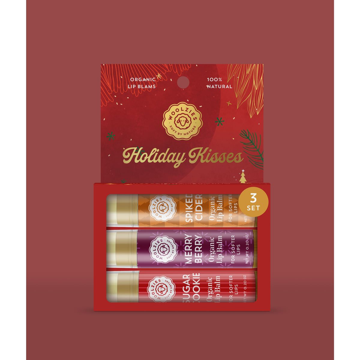 A pack of three Woolzies Holiday Kisses Organic Lip Balms with flavors "sugar cookie," "berry," and "spice" displayed in a festive red and gold cardboard packaging.