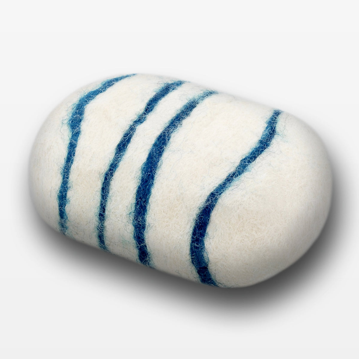 A close-up of a Fiat Luxe - Classic Bay Rum felted soap bar with three dark blue stripes, isolated on a white background. The texture of the soap appears soft and fibrous.