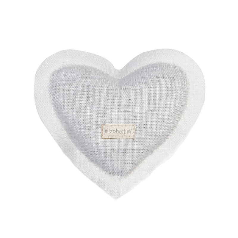 A white heart-shaped sachet with a textured fabric surface and the brand name "elizabeth W" printed in the center, filled with a herbal aroma.