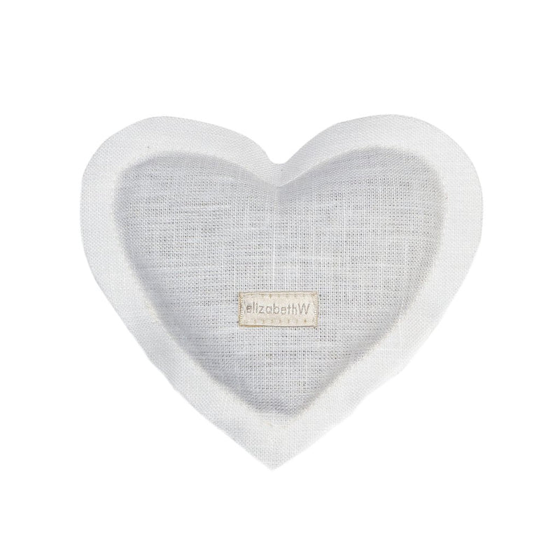 A  elizabeth W Linen Heart Sachet - Ivory made of white fabric with a label that reads "#elizabethw" in gray text, set against a white background, infused with a herbal aroma.