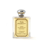 A square glass perfume bottle with a silver cap, filled with amber-colored liquid. It features an elegant label with script and block text, embodying Taylor of Old Bond Street Sandalwood Luxury Sandalwood Cologne, a masculine fougère fragrance.