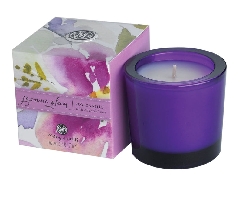 A purple Mangiacotti Jasmine Plum soy candle with essential oils in a recycled glass holder, next to its packaging box which features a watercolor design in pink and purple tones, labeled "jasmine plum.
