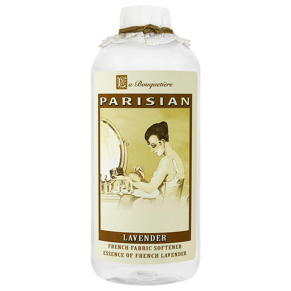 A bottle of La Bouquetiere Lavender Fabric Softener designed to fragrance your linens, with a vintage-style label featuring an illustration of a woman at a dressing table.
