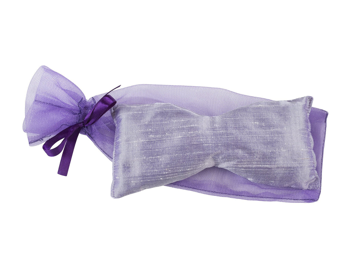 A small, rectangular Sonoma Lavender Eye Pillow made of lilac silk dupioni fabric, tied securely with a matching satin ribbon, isolated on a white background.