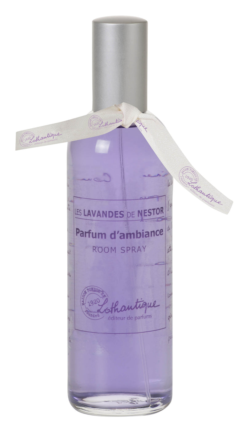 Transparent glass bottle of Lothantique les lavandes de l'oncle Nestor lavender room spray with a lavender-scented purple liquid inside and a decorative white ribbon, labeled in elegant script from Lothantique.