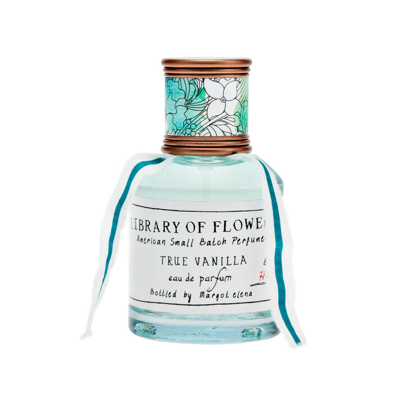 A small glass Library of Flowers True Vanilla Eau De Parfum bottle labeled "True Vanilla" with a decorative turquoise and white design on the cap and a matching ribbon tied around the neck.