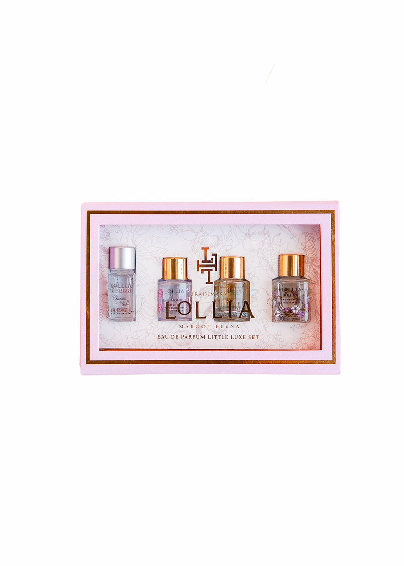 A Margot Elena Lollia Eau De Parfum Little Luxe Gift Set featuring four small bottles of various fragrances, elegantly arranged in a light pink and maroon presentation box.