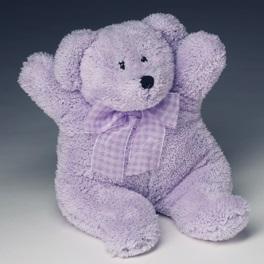 A heatable plush Sonoma Lavender "Lou" teddy bear with a checkered bow around its neck, sitting with its arms raised slightly in a welcoming gesture.