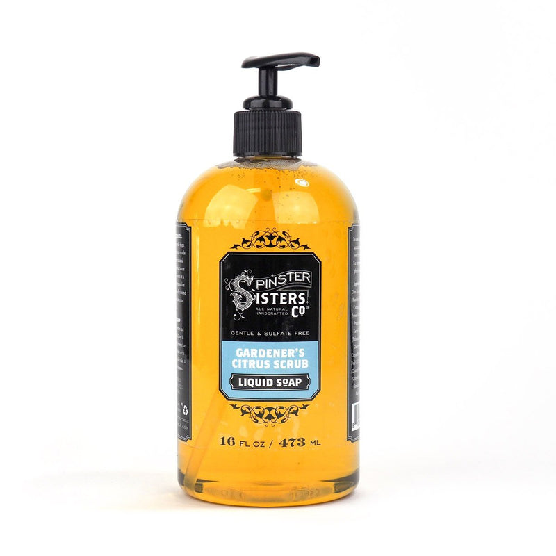 A 16 fl oz bottle of Spinster Sisters, Co. gardeners citrus scrub liquid soap with a black pump, transparent yellow contents, against a white background.