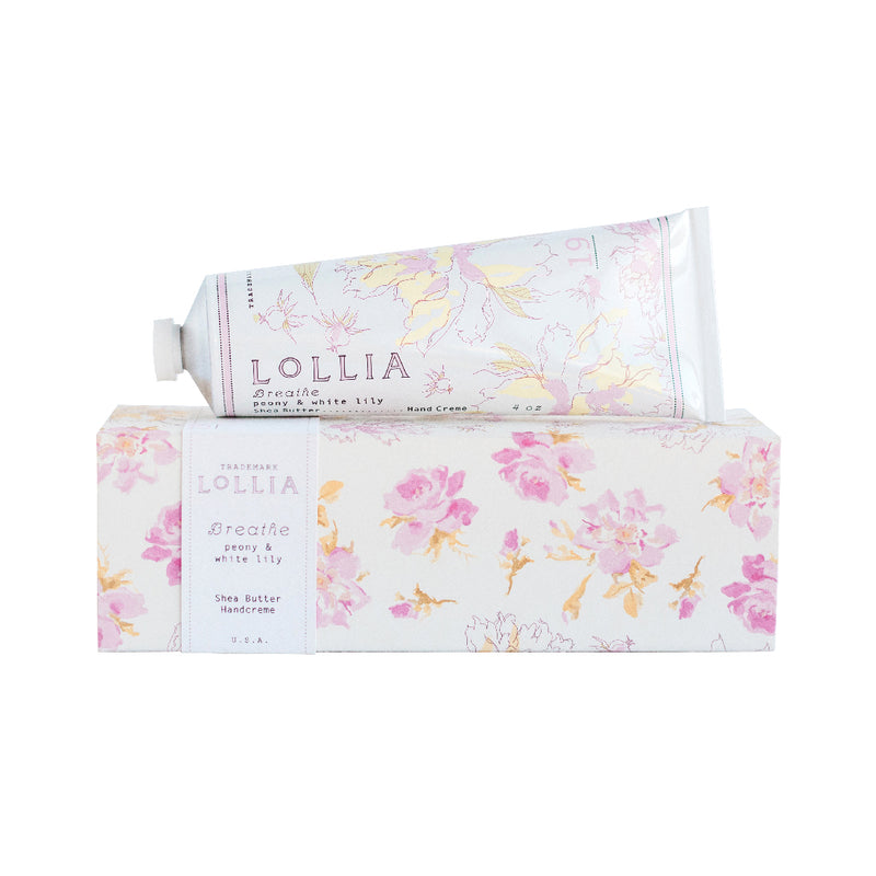 Two boxes of Margot Elena brand Lollia Breathe Hand Créme with floral designs on a white background. One box is open, displaying the tube of cream partially slid out.