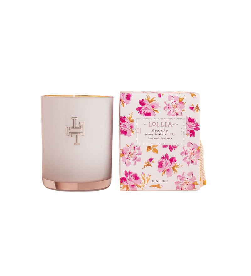 Lollia Breathe No. 19 Luminary Candle in a pink frosted handblown glass container with a metallic bottom and Margot Elena logo next to its floral-patterned packaging, labeled "lollia.