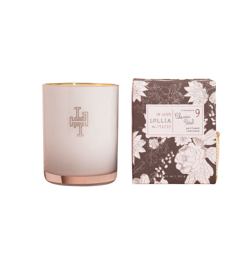 A Lollia In Love No. 09 Perfumed Luminary Candle made from a Soy wax Coconut wax blend, next to its matching floral patterned packaging with text and a design, isolated on a white background.
