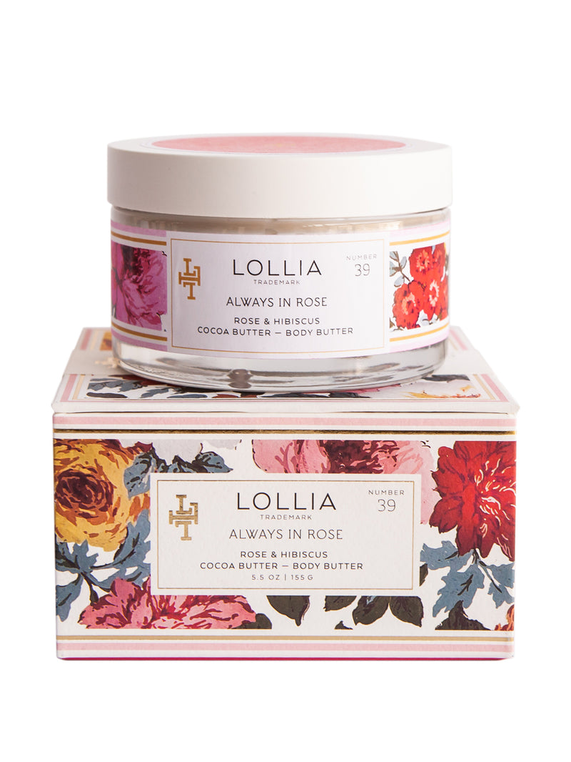 A jar of Margot Elena's Lollia Always in Rose Shea Butter Body Butter on top of its packaging box, adorned with floral patterns in vivid colors.