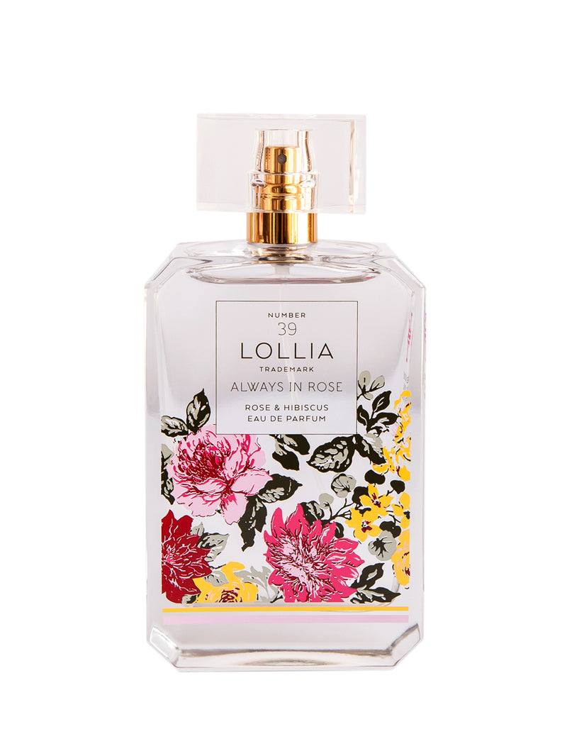 A transparent perfume bottle with vibrant hibiscus and rose designs labeled "Margot Elena Lollia Always in Rose Eau de Parfum" against a white background.