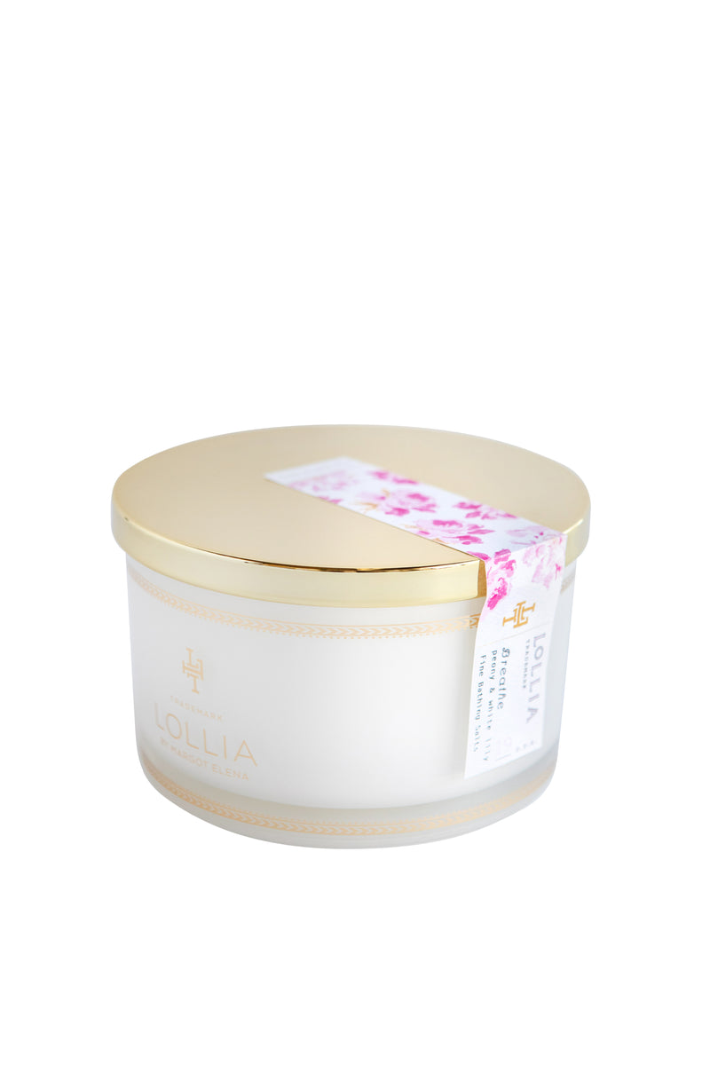 A Margot Elena branded Lollia Breathe Fine Bathing Salts container in a cylindrical shape with a golden lid, adorned with a Peony & White Lily designed label on a white background.