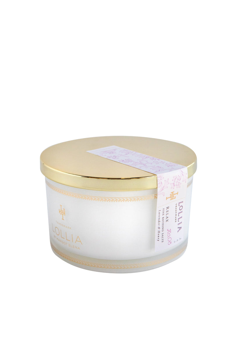 A round container of Margot Elena brand bath salts with a gold lid and a white label, featuring Tahitian Vanilla, isolated on a white background.