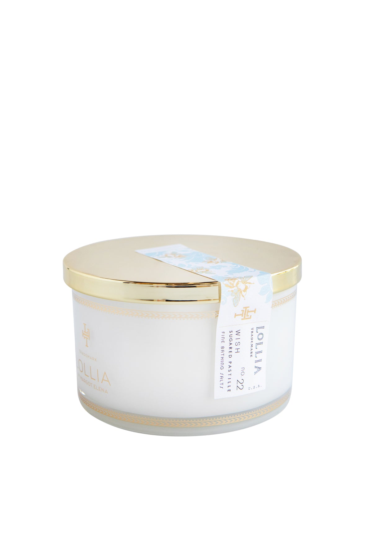 A cylindrical Margot Elena branded hand cream container with a metallic golden lid, featuring elegant white and turquoise labels adorned with Lollia Wish Fine Bathing Salts, isolated on a white background.